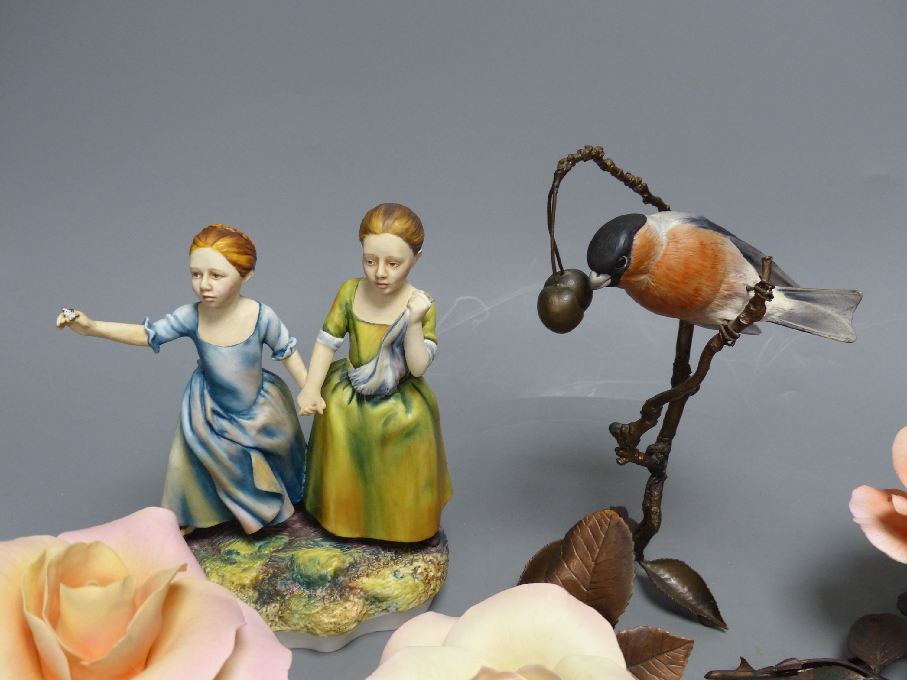 Four Boehm porcelain and bronzed metal roses, a similar model of a bullfinch eating berries and a Hereford Fine China group of two girls